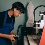 operator sedang menggunakan mesin cnc